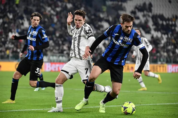 Federico Chiesa (i), delantero de Juventus, disputa el balón con Rafael Toloi, defensor de Atalanta, durante el partido de ayer.