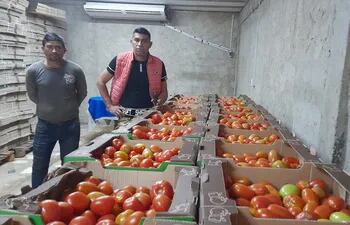 Los hermanos productores, Adilio y Abel Brítez, exhibiendo sus tomates sin poder comercializar.