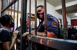 Una familiar de una persona privada de su libertad en Tacumbú se agarra de las rejas de la penitenciaría durante el motín del martes pasado.