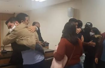 Edilberto Miranda, hermano de la víctima, abraza al abogado Albino Ramírez (i), mientras otros familiares celebran el fallo favorable.
