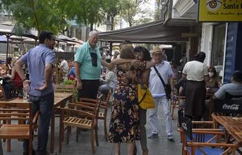 Encuentro alegre entre dos mujeres y la sonrisa de los acompañantes en calle Palma.