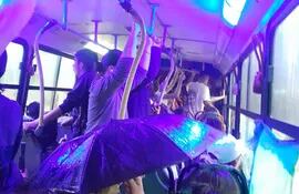 Pasajera usa paraguas dentro del bus.
