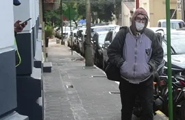 Un hombre camina abrigado en las calles del microcentro de Asunción. (Foto Ilustrativa).