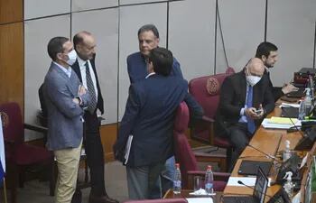 El senador Óscar "Cachito" Salomón conversa con sus colegas y un funcionario del Ejecutivo en la sala de sesiones del Senado.