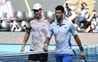 El italiano Jannik Sinner (i) y el serbio Novak Djokovic al finalizar la primera semifinal del Abierto de Australia 2024 en Melbourne, Australia.