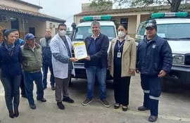 El director de la Duodécima Región Sanitaria, Dr. Anibal Espinola, hace entrega de los documentos y la  llave de la nueva ambulancia al Dr. Artemio Velazquez de Villalbín y la Lic Estela Coronel de San Juan de Ñeembucú.