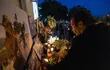 Un hombre enciende una vela frente a la foto de Halyna Hutchins, que fue recordada con una vigilia en Burbank, California.