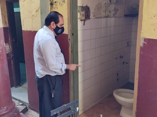 El presidente de Sinadi, Miguel Marecos, observa los baños que no están en condiciones en la escuela básica 1, República Argentina, de Asunción.