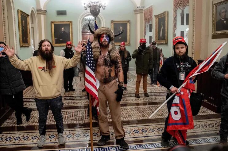 En esta foto de enero de este año, partidarios del presidente norteamericano Donald Trump, incluido Jake Angeli (C), un miembro de QAnon conocido por su particular look.