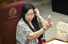 La senadora cartista Norma Aquino (alias Yami Nal), se retoca el pelo durante la sesión en la que se discute la pérdida de investidura de su colega Katty González (PEN).
