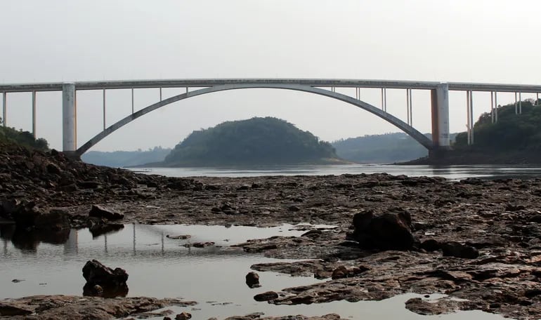 Parte del lecho del río Paraná queda al descubierto con la sequía. A través del Puente de la Amistad se observa al isla Acarai (Brasil).