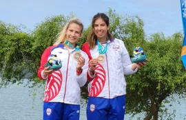 Las paraguayas Alejandra Alonso (i) y Nicole Martínez celebran la conquista de la medalla de bronce en la premiación del Remo en los Juegos Panamericanos Santiago 2023.