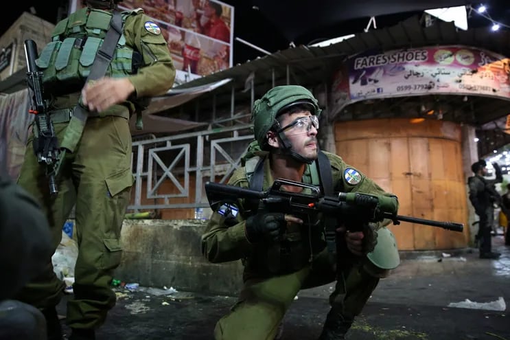 Soldados israelíes durante un enfrentamiento con manifestantes palestinos este martes en la ciudad de Hebrón.