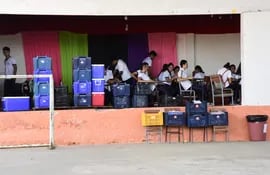 Con una sensación térmica sobre los 47°C, alumnos del tercer ciclo dan clases en un pequeño escenario, entre las conservadoras del almuerzo escolar amontonadas en la escuela Clara Piacentini de Cacace, de Asunción.