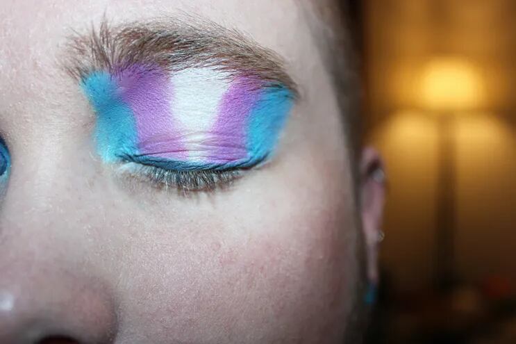 Imagen de referencia: una persona maquillada en los ojos con los colores de la bandera transgénero.
