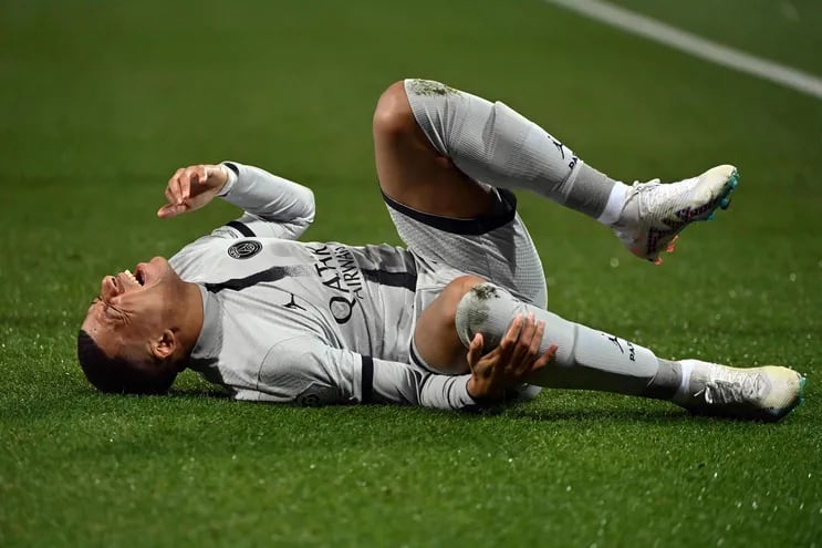 El delantero francés del Paris Saint-Germain, Kylian Mbappe, yace en el suelo después de lesionarse durante el partido de fútbol de la L1 francesa entre el Montpellier Herault SC y el Paris Saint-Germain (PSG) en el Stade de la Mosson en Montpellier, sur de Francia, el 1 de febrero de 2023.