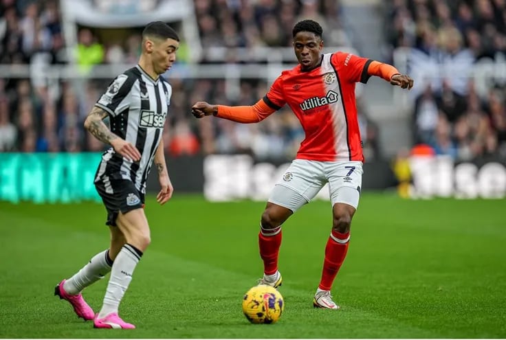 Miguel Almirón intenta dominar el balón ante la marca de Chiedozie Ogbene, jugador del Luton Town, durante el partido que el Newcastle empató ayer de local 4-4 con el equipo recién ascendido.