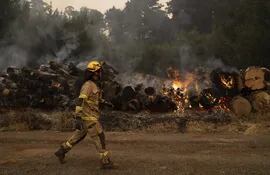 Los bomberos trabajan duramente para intentar extinguir el fuego, este martes en Santa Juana, región Biobío (Chile).