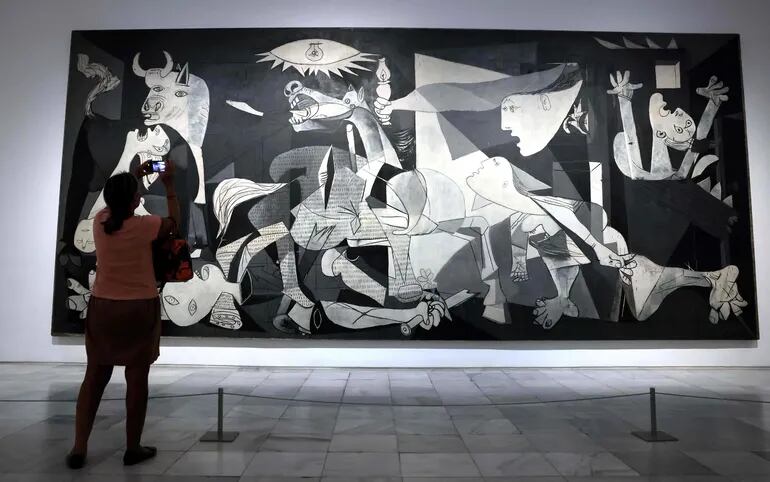 Un visitante fotografía la obra "El Guernica" expuesta en el museo Reina Sofía, de Madrid, España.