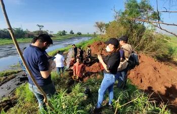 La fiscala Daisy Sánchez da indicaciones a los que realizan la búsqueda de restos óseos de Luz Dahiana Espinoza en el estanque de Guarambaré.