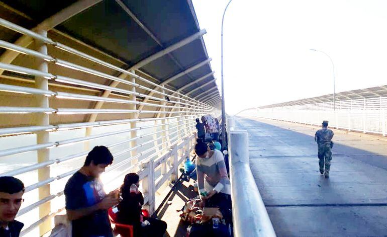 Compatriotas aguardan en la pasarela del Puente de la Amistad para ingresar al Paraguay. Cada día llegan desde Brasil los desocupados.