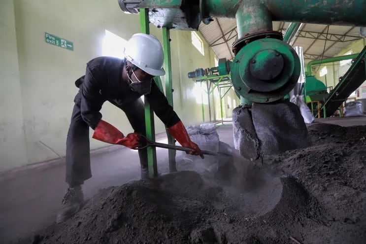 Un trabajador de Kenia recolecta lodos de desechos humanos secos que se muelen y mezclan con aserrín proveniente de un horno después de ser calentado en la etapa de carbonización en la planta de procesamiento de la Compañía de Servicios de Agua y Saneamiento de Nakuru.