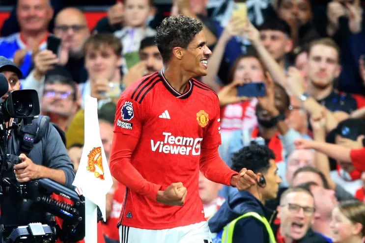 Manchester United's French defender #19 Raphael Varane celebrates scoring the opening goal during the English Premier League football match between Manchester United and Wolverhampton Wanderers at Old Trafford in Manchester, north west England, on August 14, 2023. (Photo by Lindsey Parnaby / AFP) / RESTRICTED TO EDITORIAL USE. No use with unauthorized audio, video, data, fixture lists, club/league logos or 'live' services. Online in-match use limited to 120 images. An additional 40 images may be used in extra time. No video emulation. Social media in-match use limited to 120 images. An additional 40 images may be used in extra time. No use in betting publications, games or single club/league/player publications. / 