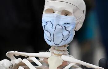 Un esqueleto falso con una máscara que lleva la leyenda "SOS".
