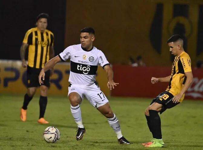 Marcos Gómez (i), de Olimpia, controla el balón ante la marca de Romeo Benítez (d), en Dos Bocas.