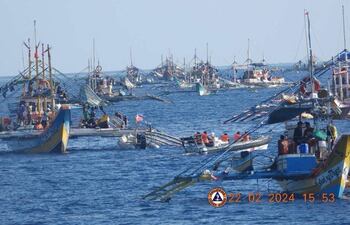This handout photo taken on February 22, 2024 and received on February 25, 2024 from the Philippine Coast Guard shows China Coast Guard personnel onboard a rigid-hulled inflatable boat (centre R) shadowing a Philippine Bureau of Fisheries and Aquatic Resources (BFAR) inflatable boat (centre L) while it delivers supplies to fishermen during a mission led by the BRP Datu Sanday near the China-controlled Scarborough Shoal in the disputed South China Sea. The Philippines on February 25 accused the Chinese coast guard of attempting to block the Filipino government vessel BRP Datu Sanday delivering supplies to fishermen, the second such alleged incident near a disputed reef in two weeks. (Photo by Handout / Philippine Coast Guard (PCG) / AFP) / RESTRICTED TO EDITORIAL USE - MANDATORY CREDIT "AFP PHOTO / Philippine Coast Guard" - NO MARKETING NO ADVERTISING CAMPAIGNS - DISTRIBUTED AS A SERVICE TO CLIENTS