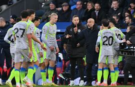 El entrenador español del Manchester City, Pep Guardiola, habla con sus jugadores durante el partido de fútbol de la Premier League inglesa entre el Crystal Palace y el Manchester City en Selhurst Park, en el sur de Londres