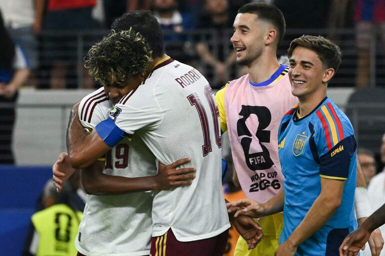 El delantero de España Lamine Yamal (izq.) y el centrocampista de España Rodri (centro) se abrazan al celebrar la victoria de su equipo al final del partido de semifinales del torneo de fútbol de la Copa Mundial 2026 entre Francia y España en el Dallas Stadium en Arlington.