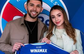 Julio Enciso y su inseparable esposa Melissa Cardona mostrando la nueva camiseta que lucirá el paraguayo en el Racing de Estrasburgo.