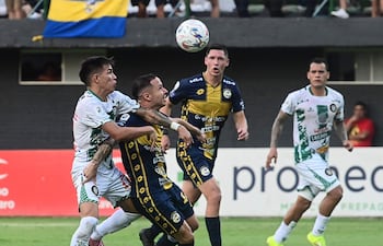 Juan Giménez de Rubio Ñu y Sergio Mendoza de Trinidense disputan la posición del balón en el duelo de vecinos en Trinidad.