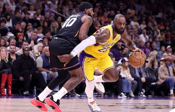LeBron James #23 de los Los Angeles Lakers avanza hacia la canasta contra Royce O'Neale #00 de los Phoenix Suns durante la primera mitad en el Mortgage Matchup Center, en Phoenix, Arizona.
