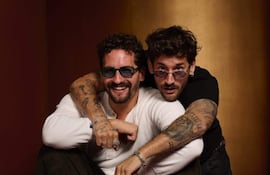 Mau y Ricky sonrientes, vistiendo zapatillas de moda, con colores vibrantes y actitud alegre antes del esperado concierto.