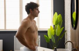 Hombre se examina en el espejo.