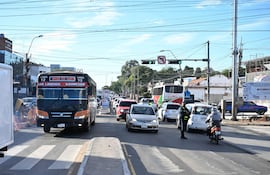 Agente de tránsito dirigiendo el tráfico en una intersección con autobús de la Línea 12 y vehículos en embotellamiento.