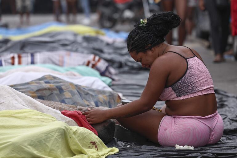 Una mujer llora frente a un cuerpo sin vida en una calle este miércoles, en Río de Janeiro (Brasil).