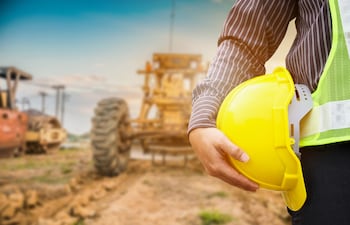 Empresario e ingeniero de construcción con casco protector amarillo en una obra.