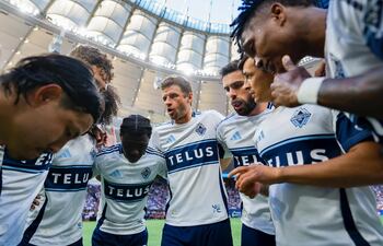 Los jugadores del Vancouver Whitecaps, incluido el volante paraguayo Andrés Cubas, escuchan la arenga del delantero alemán, Thomas Müller.