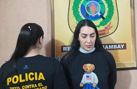Dos mujeres en oficina del Departamento Contra el Crimen Organizado, una lleva camiseta policial y otra un suéter negro con un diseño de oso.