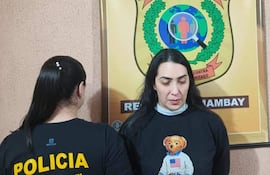 Dos mujeres en oficina del Departamento Contra el Crimen Organizado, una lleva camiseta policial y otra un suéter negro con un diseño de oso.