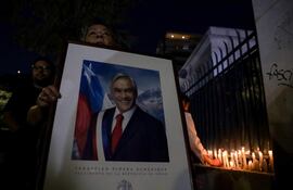 Militantes de Renovacion Nacional encienden velas en la sede del partido en apoyo al expresidente de Chile Sebastían Piñera hoy, en Santiago (Chile). Piñera murió ayer al estrellarse el helicóptero que al parecer pilotaba sobre el Lago Rengo, en el sur del país, informó su oficina. EFE/ Ailen Díaz
