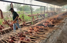 Un trabajador participando en los trabajos de cocciòn de la carne vacuna