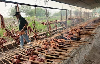 Un trabajador participando en los trabajos de cocciòn de la carne vacuna