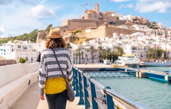 Joven visitando la ciudad costera de Ibiza en vacaciones de invierno en Al Faro, Islas Baleares, España.