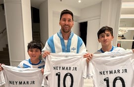 El astro argentino Lionel Messi posando con sus hijos Thiago Messi y Mateo Messi con las camisetas de Santos FC obsequiada por el brasileño Neymar Jr.