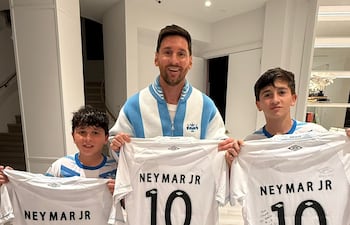 El astro argentino Lionel Messi posando con sus hijos Thiago Messi y Mateo Messi con las camisetas de Santos FC obsequiada por el brasileño Neymar Jr.