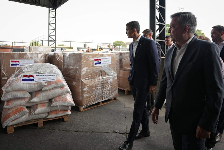 Fotografía cedida por la Presidencia de Paraguay, Santiago Peña (c), inspeccionando ayuda humanitaria que fue enviada a Colombia, este sábado.